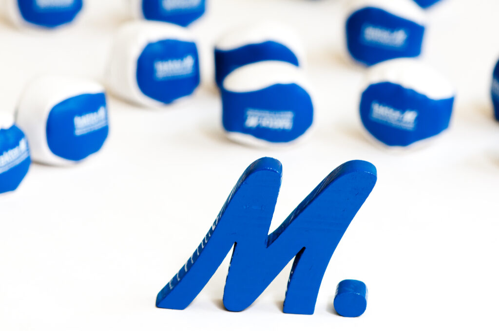 Blaue Schaumstoffbälle und ein blaues M. mit dem Logo von faktorM.